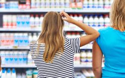 Mother and children are choosing dairy products in shop